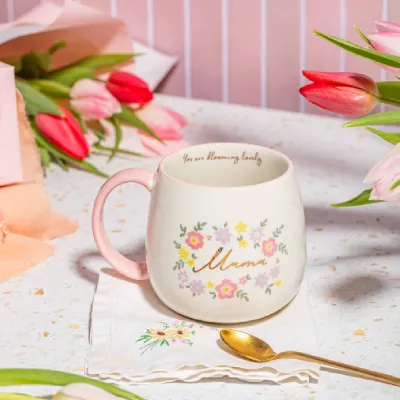 Taza Mamá de cerámica con diseño floral, rodeada de tulipanes rosas sobre mesa clara - Happyideas