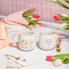 Escena de estilo con dos tazas Mamá y mantel con tulipanes rosas, sobre fondo de tela a rayas - Happyideas
