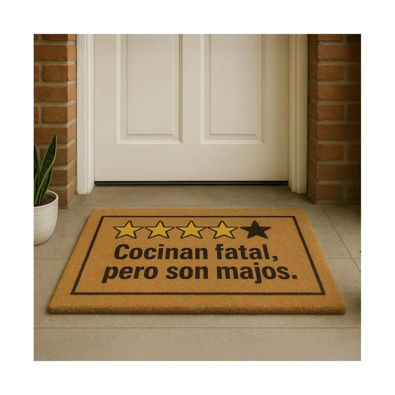Felpudo "Cocinan fatal, pero son majos" colocado frente a una puerta blanca, vista en ángulo bajo - Happyideas