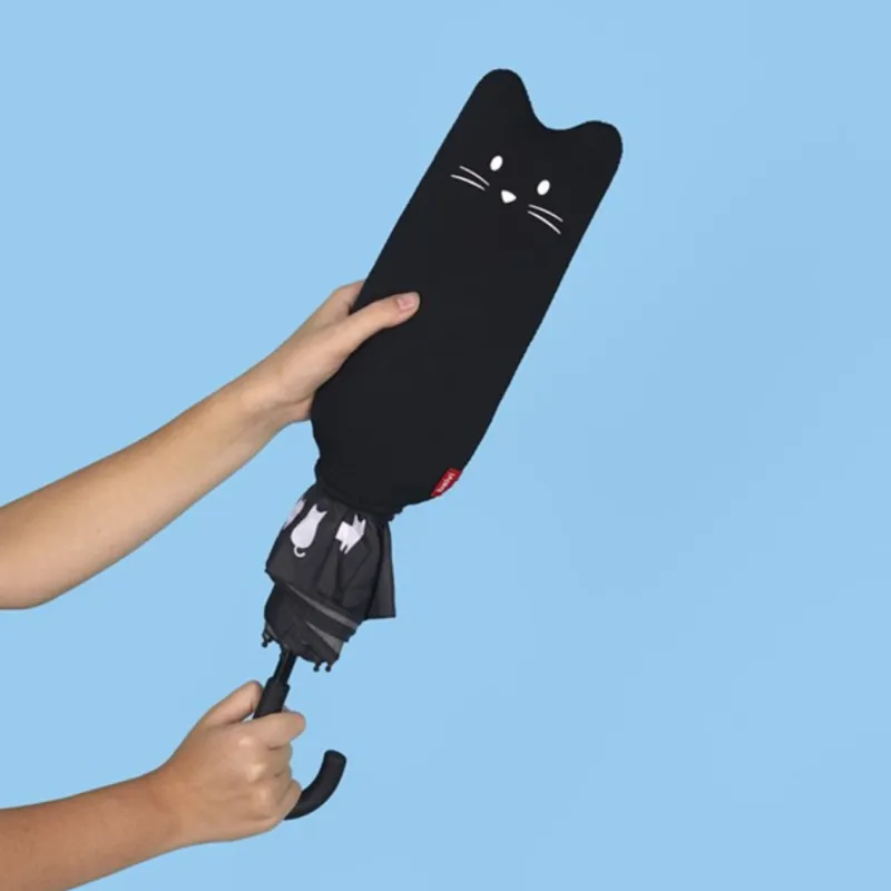 Mano sujetando el paraguas Meow cerrado con funda con forma de cabeza de gato negro, sobre fondo azul verdoso - Happyideas