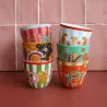 Taza Letra D junto a otras tazas monograma apiladas en dos columnas de colores frente a una pared de azulejos - Happyideas