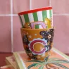 Taza Letra C, portada del producto, con rayas verdes y blancas apilada sobre otra taza de estampado floral naranja - Happyideas