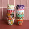 Taza Letra C junto a otras tazas monograma apiladas en dos columnas de colores frente a una pared de azulejos - Happyideas