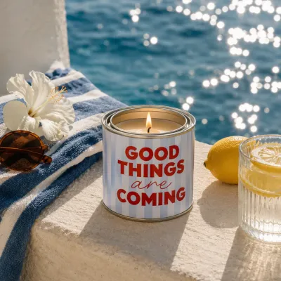 Vela en lata Good Things Are Coming encendida junto al mar