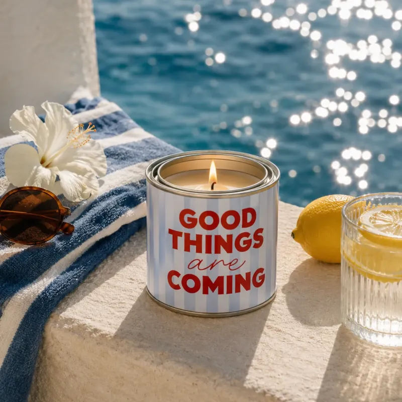 Vela en lata Good Things Are Coming encendida junto al mar