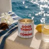 Vela en lata Good Things Are Coming encendida junto al mar