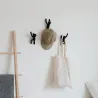 Perchas Buddy negras colocadas en la pared con un abrigo colgado