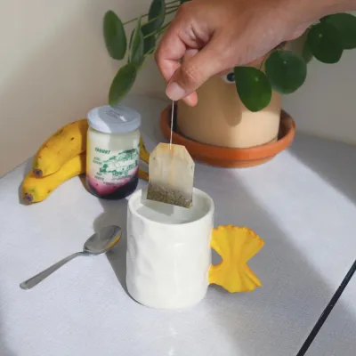 Taza Pasta, portada del producto junto a una planta en maceta de terracota y un plátano - Happyideas