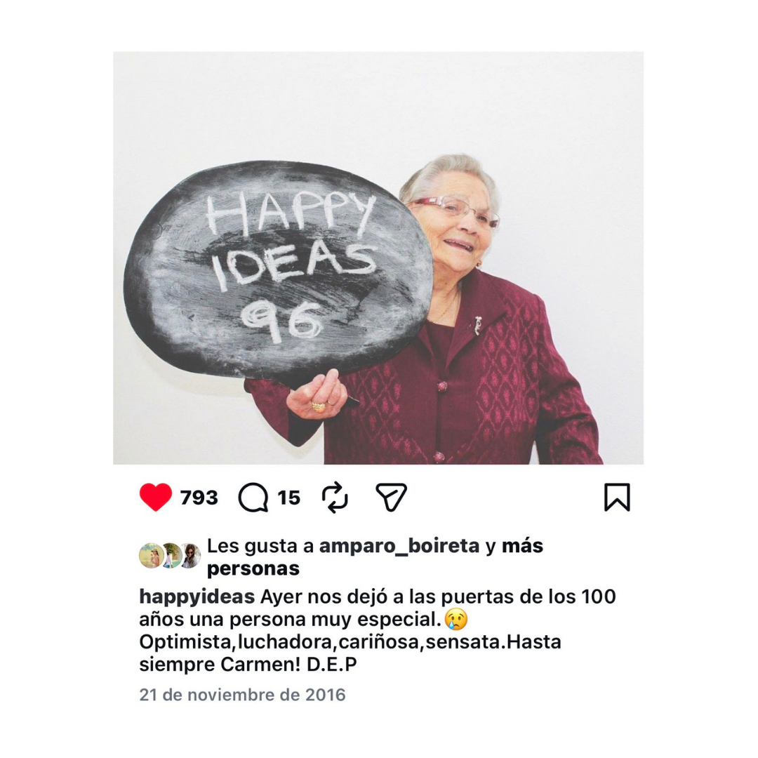 Carmen, con 96 años, sosteniendo una pizarra con el logo de Happyideas