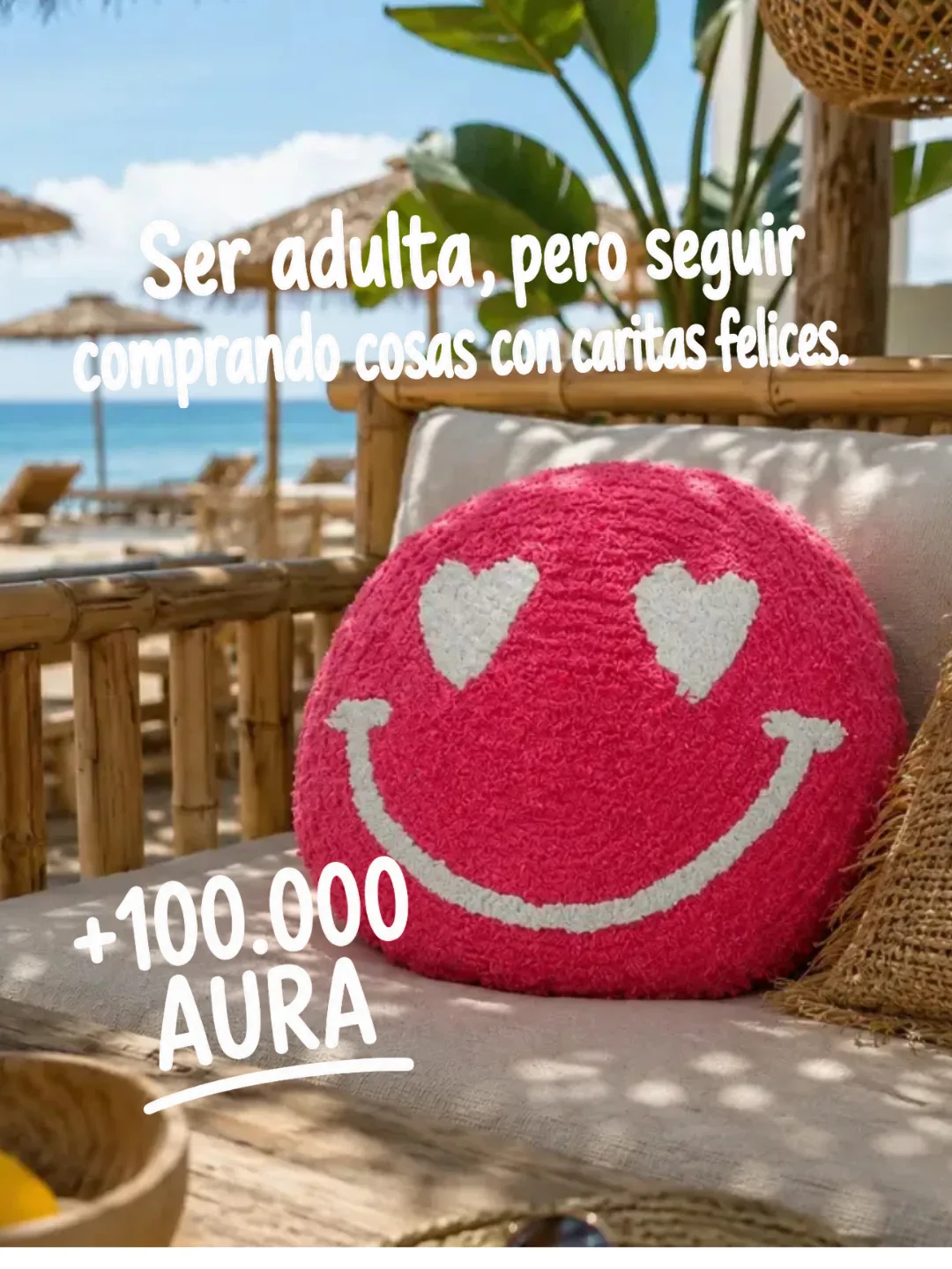Cojín Smiley rosa de Happyideas con ojos de corazón sobre un banco frente al mar