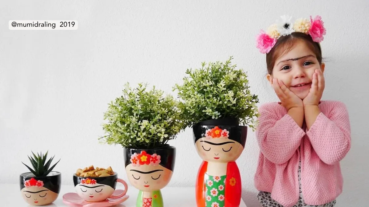Macetas y taza Frida de Happyideas junto a una niña en 2019