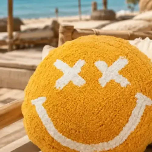 Cojín sonriente amarillo en un rincón de descanso, regalos relajantes para una amiga