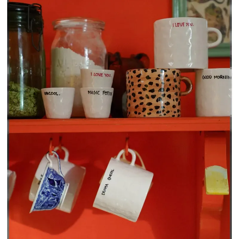 Taza Espresso Drama Queen junto a otras tazas espresso con frases en una estantería