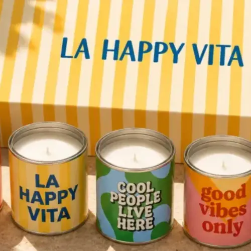 Cinco velas aromáticas Happyideas en lata junto a su caja de regalo